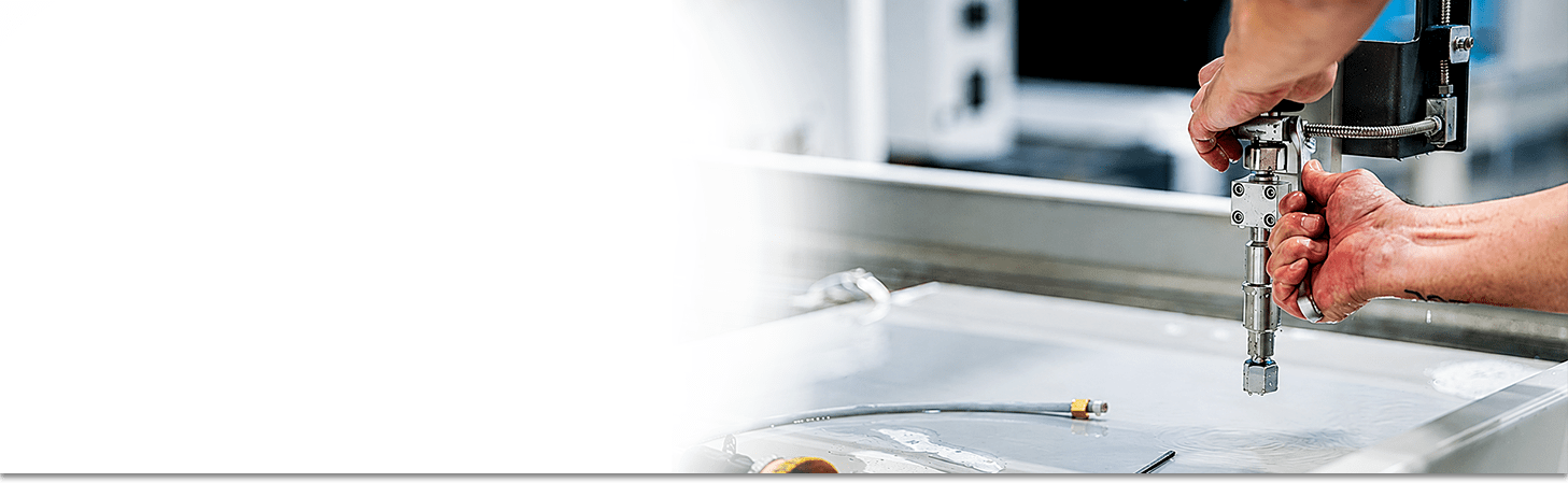 A flow waterjet technician working on a cutting head.